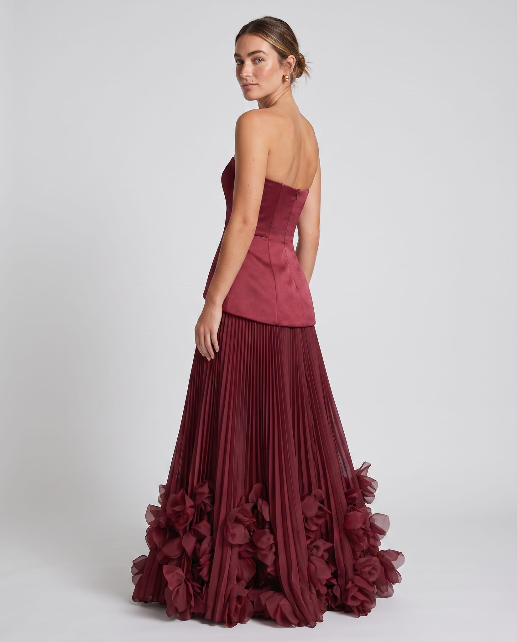 Seraphina Gown Cherry Lacquer – model back view over shoulder, light gray studio